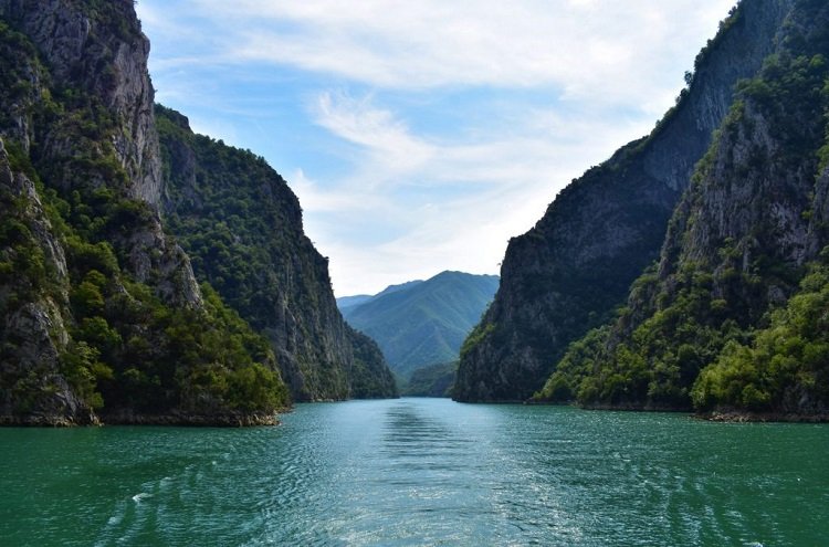 Formed as a result of hydro power plant constructions, Lake Koman washes the high peaks of the surrounding mountains.